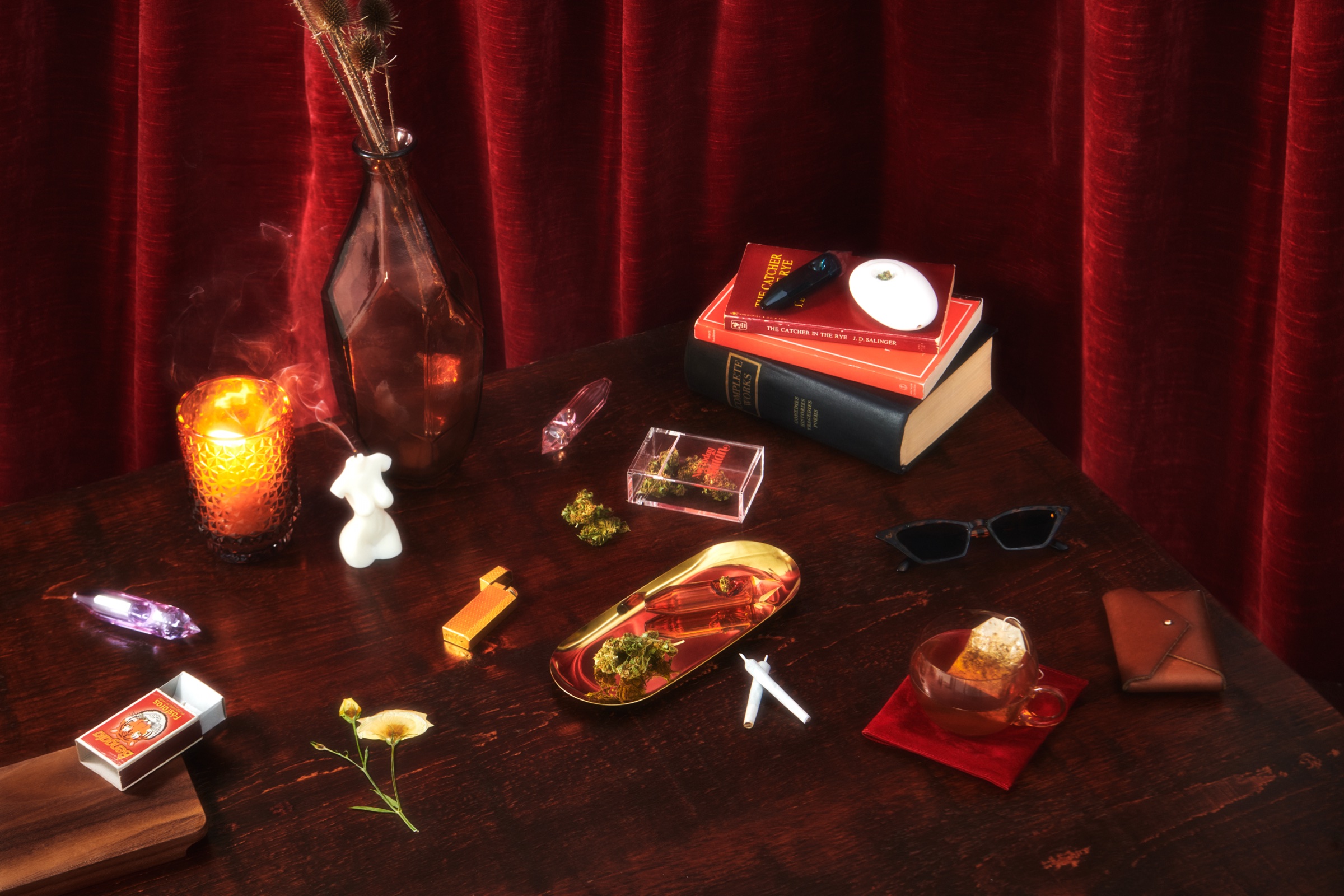 Drool smoking accessories in a theatrical red-curtain still life